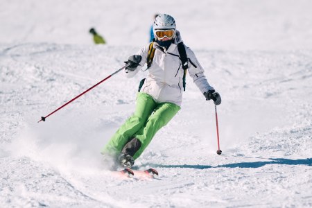 Skifahrerin fährt die Piste hinuter