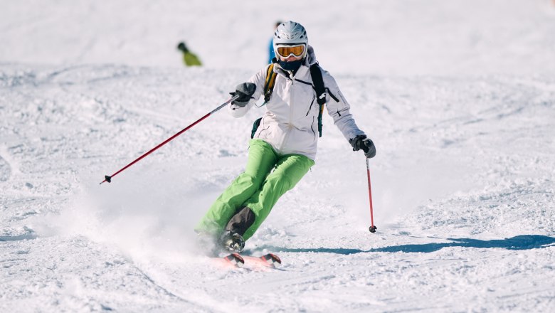 Skifahrerin fährt die Piste hinuter